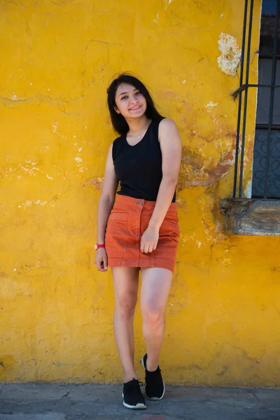 Fille voyageuse dans la ville coloniale - Femme hispanique debout devant un vieux mur jaune - Jeune femme pose dans les rues de la ville historique Guatemala — Photo