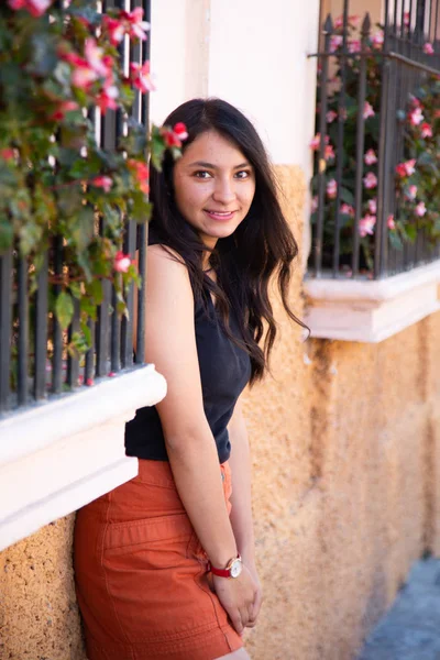 Retrato de mulher hispânica em ruas coloniais e antigas - jovem sorrindo na varanda cheia de flores - menina turística na América Latina, Guatemala — Fotografia de Stock