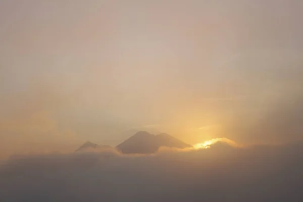 Tramonto con nuvole che circondano montagne e vulcani - Bellissimi paesaggi vulcanici in Guatemala — Foto Stock