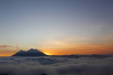 Ateş ve Acatenango volkanı üzerinde gün batımı - bulutlarla çevrili volkanlar - Guatemala yanardağlarının manzarası