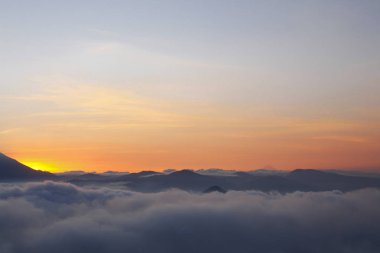 Renkli gökyüzü ve dağların üzerinde birçok bulutla gün batımı - Guatemala 'da Volkan Atitlan arka planı - manzaralar
