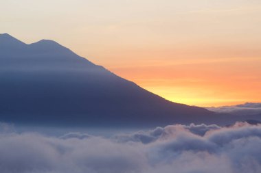 Renkli gökyüzü ve dağların üzerinde birçok bulutla gün batımı - Guatemala 'daki manzaralar