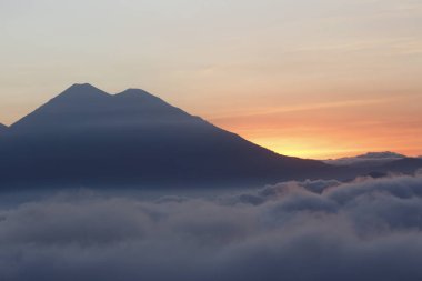 Renkli gökyüzü ve dağların üzerinde birçok bulutla gün batımı - Guatemala 'daki manzaralar