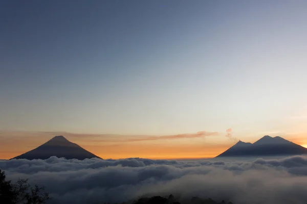 Tramonto sul vulcano di fuoco, vulcano Acatenango e vulcano acquatico - vulcani circondati da nuvole - Veduta dei vulcani del Guatemala — Foto Stock