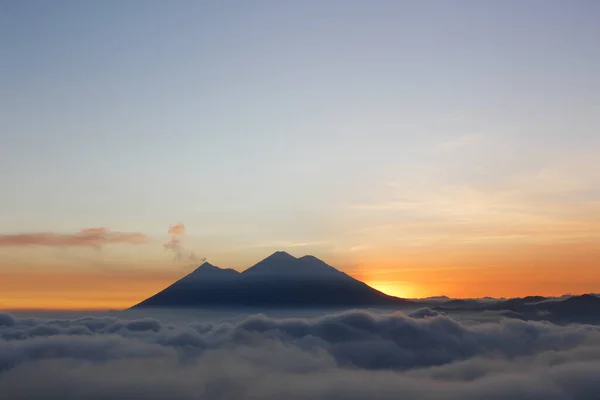 Pôr do sol sobre Vulcão de Fogo e Vulcão Acatenango - vulcões cercados por nuvens - Uma vista dos vulcões da Guatemala — Fotografia de Stock