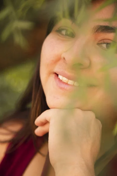 Hispanic woman smiling in the middle of trees - detail of natural smile - Latin woman