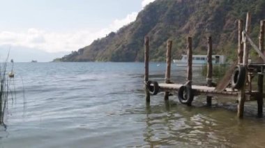 Atitlan Gölü 'ndeki rustik ahşap iskele, Guatemala, mavi gökyüzü manzarası Panajachel Gölü üzerindeki bulutlarla çevrili mavi gökyüzü