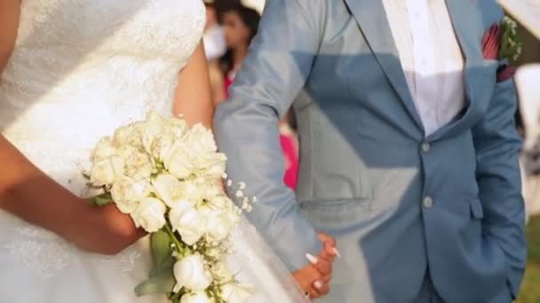 新郎和新娘在自然的婚礼上 夫妻在日落时结婚 手里拿着一束白玫瑰 — 图库视频影像