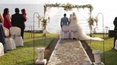 Çiftler gün batımında Guatemala 'da Atitlan Gölü' nde evleniyor. Çiçekler, çimenler, göl ve volkan manzarasıyla çevrili doğal bir düğün.
