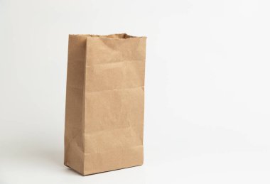 Beyaz zemin üzerinde kağıt torba modeli - çevre dostu ve yeniden kullanılabilir malzemelerden yapılmış el işi kağıt torbası