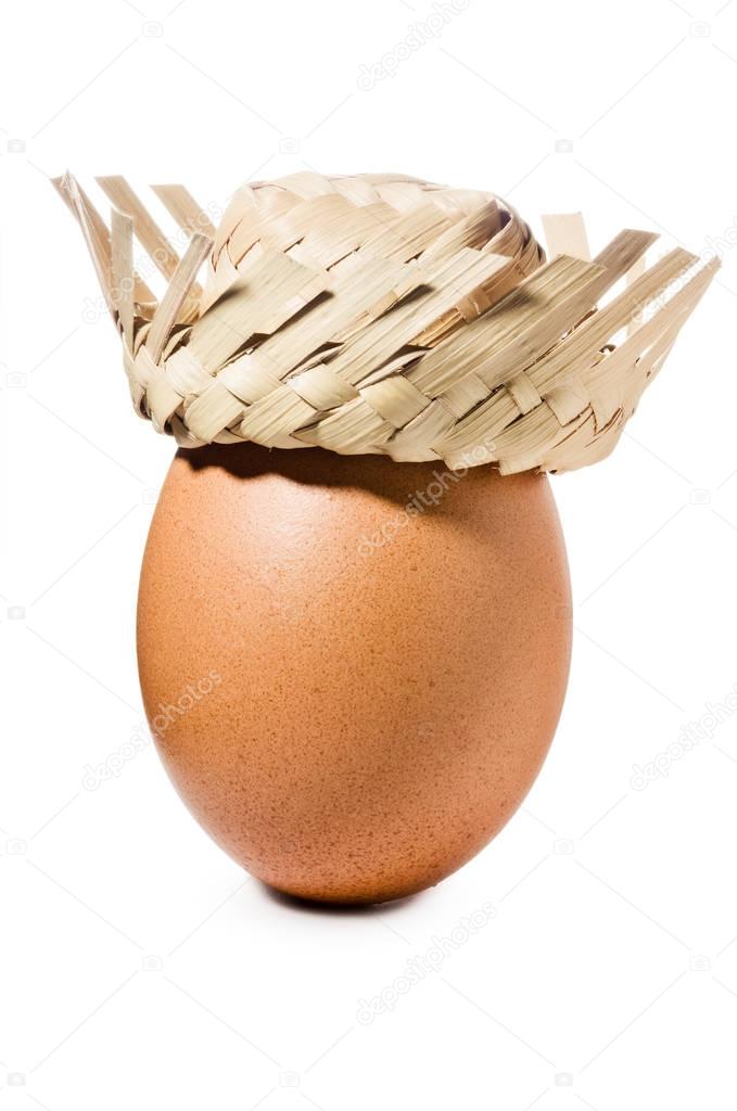 Brown egg with straw hat isolated on white background