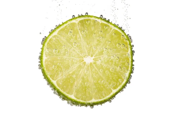 Slice of lime lemon in water with bubbles — Stock Photo, Image