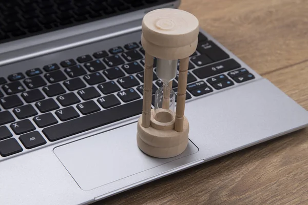 Egg timer or hourglass on an open business laptop
