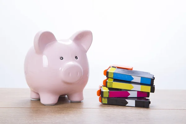 Cute pink piggy bank with ink cartridges — Stock Photo, Image