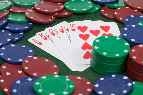 Playing cards on table beside stacked poker chips — Stock Photo, Image