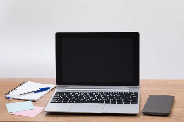 Escrivaninha com laptop e telefone celular — Fotografia de Stock