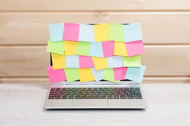 Bir dizüstü bilgisayar kapsayan rasgele boş yapışkan notlar