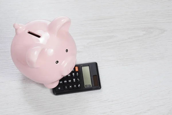 Piggy bank with zero on calculator — Stock Photo, Image