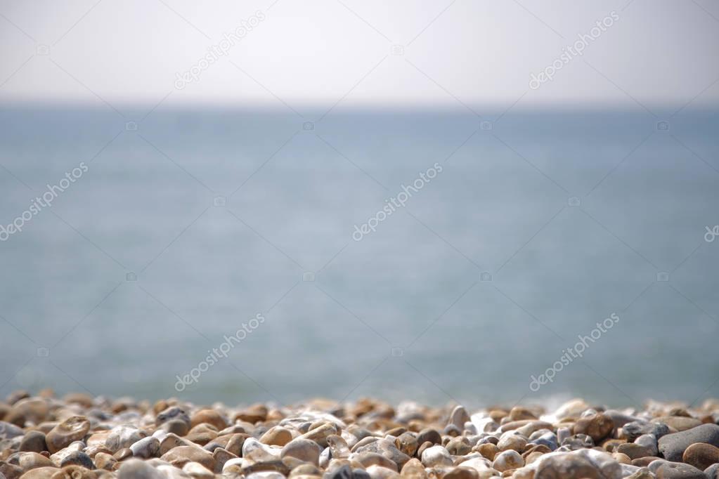 Blurred ocean view with pebbles