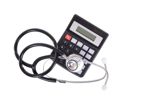 Calculator with stethoscope over white — Stock Photo, Image