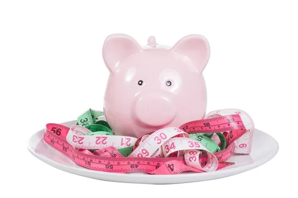Piggy bank surrounded by three unwound tapes — Stock Photo, Image