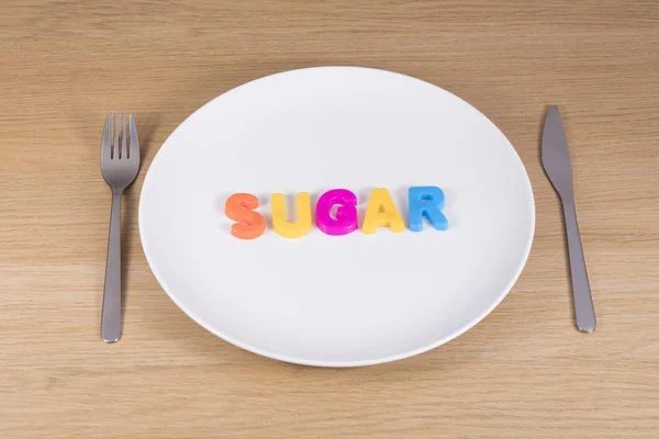 Een mes, een vork en een leeg bord met het woord suiker — Stockfoto