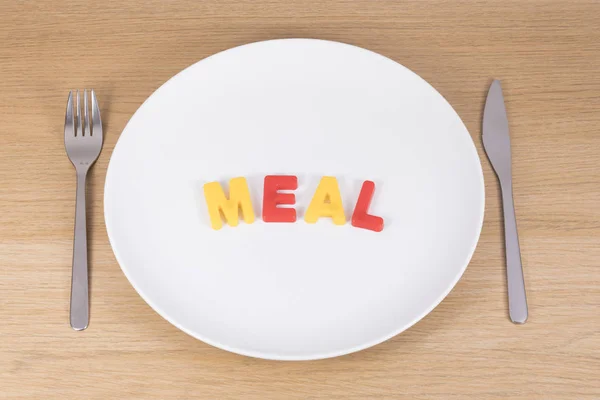 A knife, fork and empty plate with the word meal — Stock Photo, Image