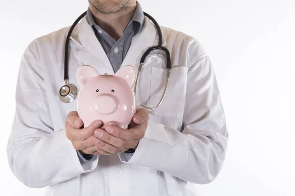 Médico segurando um porquinho rosa em suas mãos — Fotografia de Stock