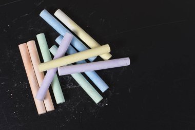 Bir kara tahta üzerinde renkli tebeşirler topluluğu