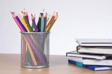 Kitaplar tarafından ayakta renkli kalemler ile konteyner