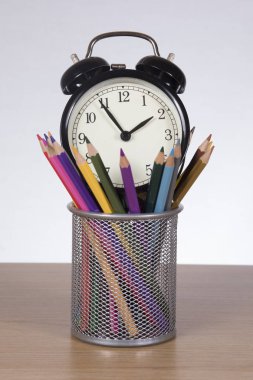 Renkli kalemler ile kapsayıcısında çalar saat