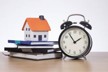 Saat ve kitaplar tik tak ile ev finansman kavramı