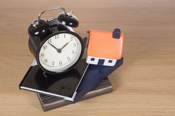 Concept de prêt à domicile avec horloge, livres et maison — Photo