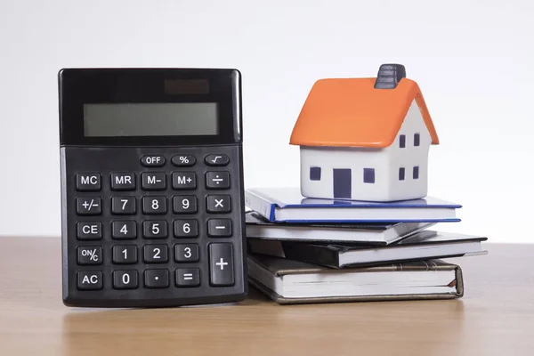 Modellhaus auf Büchern mit Taschenrechner — Stockfoto