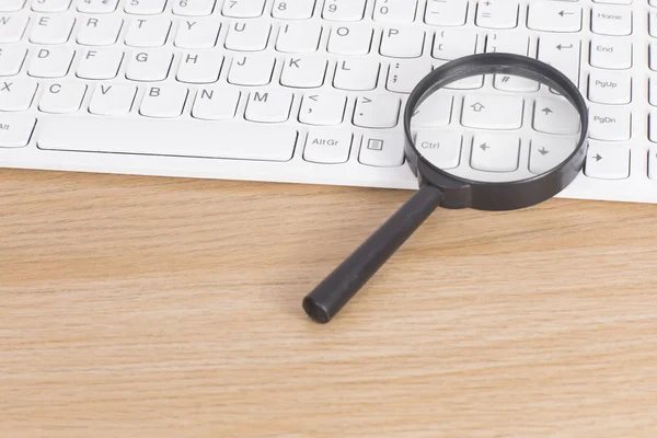 stock image Small magnifying glass on a computer keyboard