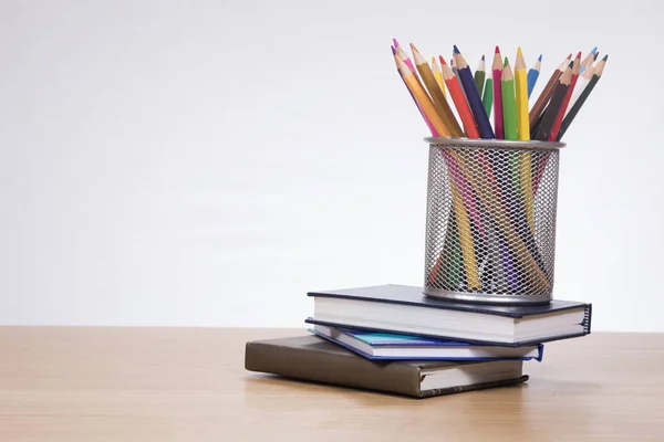 Halter mit Buntstiften auf Büchern — Stockfoto