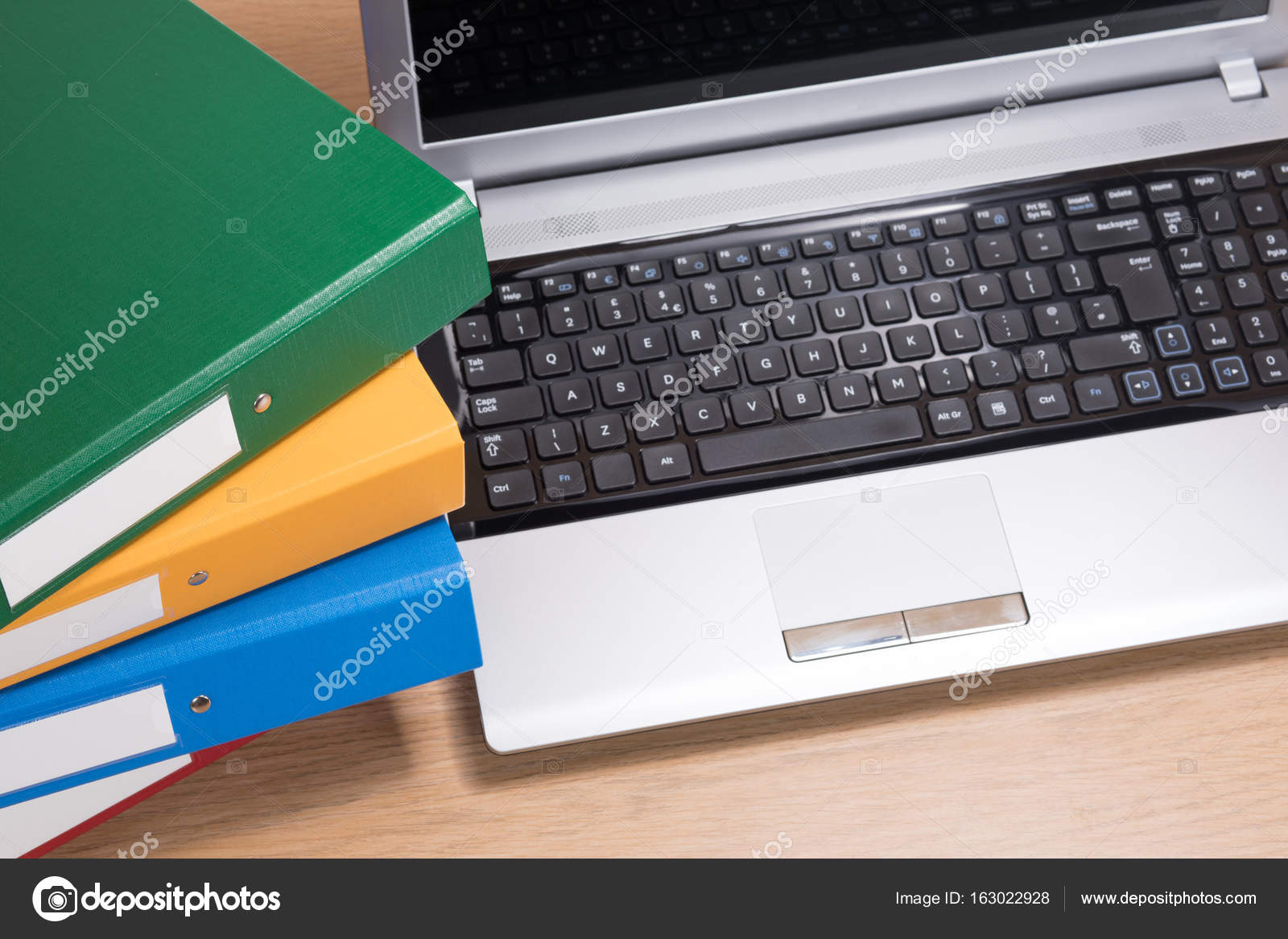Neat Office Desk With Laptop And Stacked Folders Stock Photo