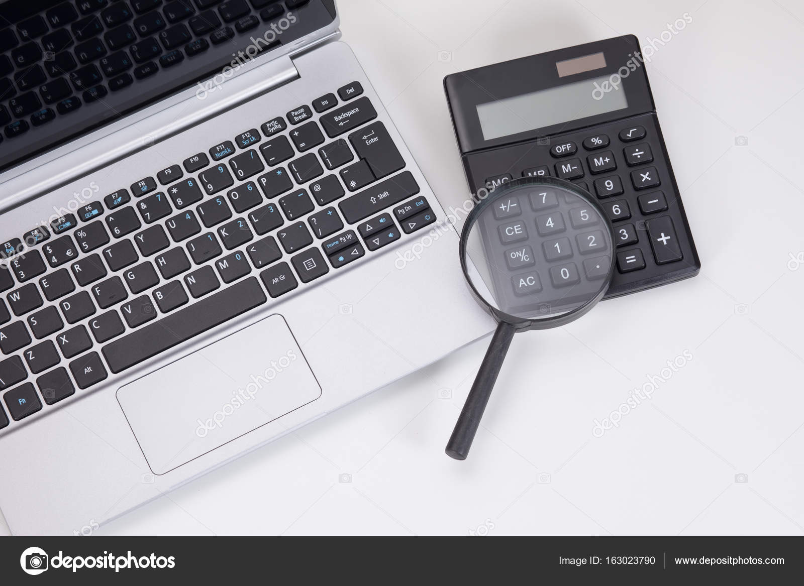 Calculator, keyboard and magnifier budget concept — Stock Photo