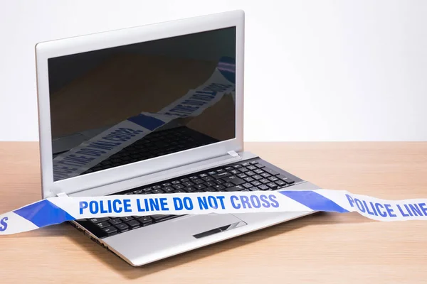 Laptop de escritório em branco e fita da cena do crime da polícia — Fotografia de Stock