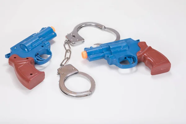 Två plast handeldvapen med handfängsel och kopia utrymme — Stockfoto