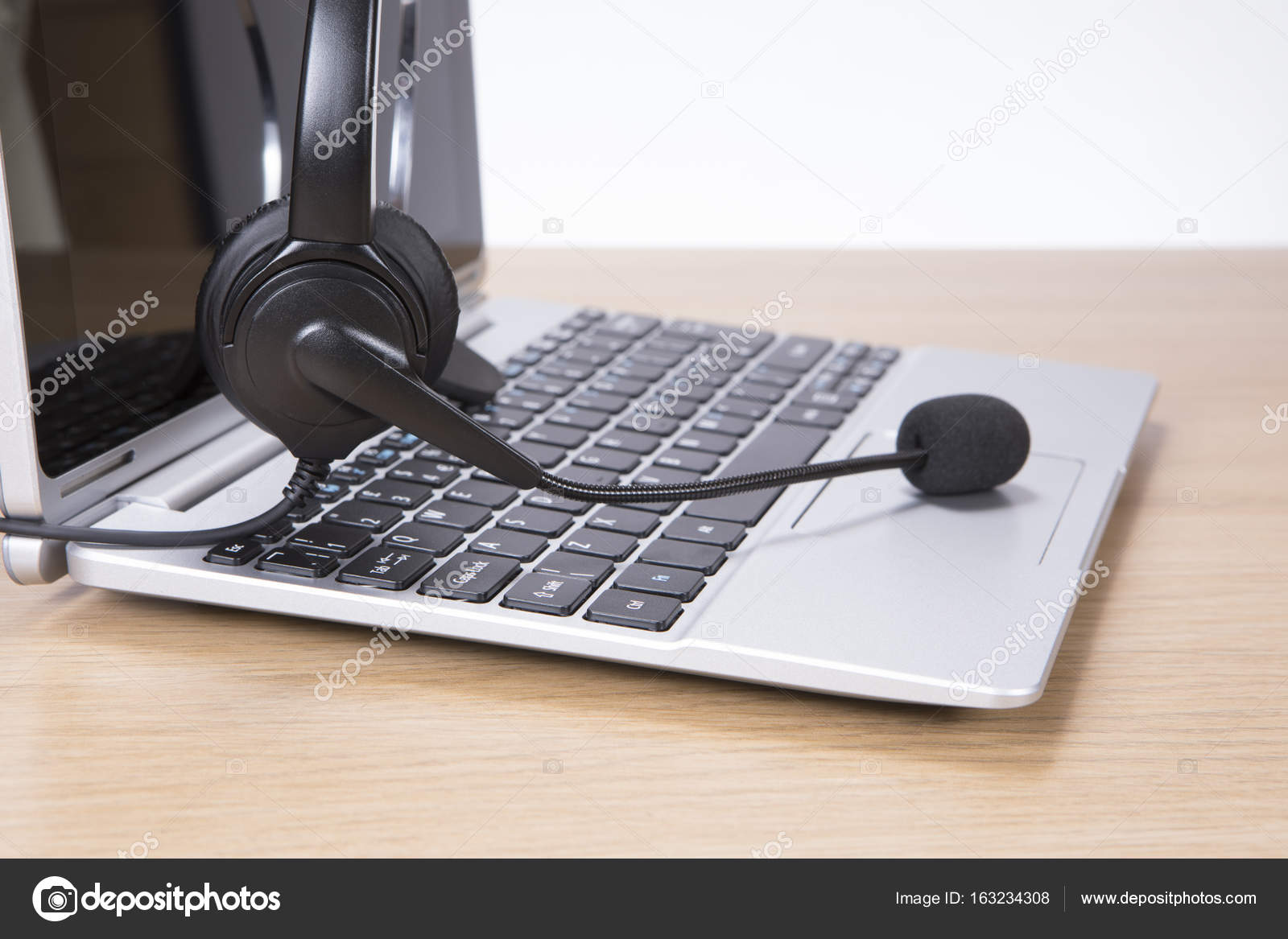 Open laptop computer with headset Stock Photo by mattkusb 163234308