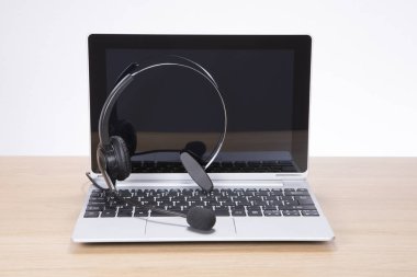 Açık laptop klavye üzerinde dengeli bir kulaklık ile