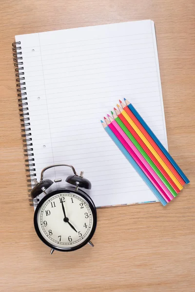 Renkli kalemler defter üzerinde yalan ile çalar saat