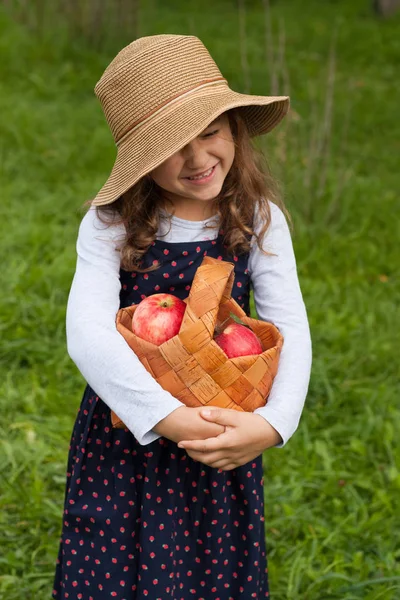 Little Girl With Red Apples In Basket