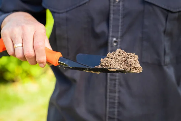 Hand Hold Garden Trowel With Soil In Garden. — Stock Photo, Image