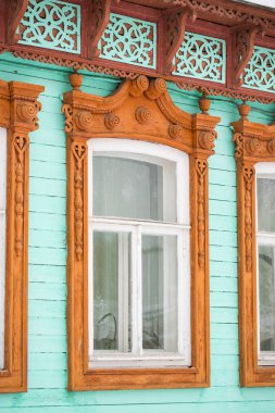 Kahverengi ve yeşil renkli oyulmuş camları olan güzel ahşap kırsal evi kapatın..