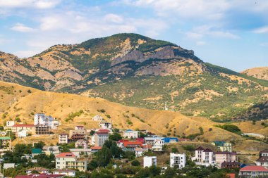 Yazın güneşli bir günde Kırım 'daki Kırım' da yerleşim yerlerinde ağaçlarla kaplı güzel dağ manzaraları..