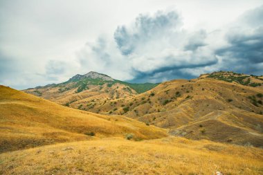 Yazın Kırım, Ukrayna 'da dramatik Cumulonimbus Bulutları Altında Kuru Sarı Çimenli Güzel Manzara Tepeleri.