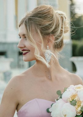 Gelin moda. Şık makyaj ve saç modeli Şakayık buket onun elinde tutan genç güzel modern gelin portresi.