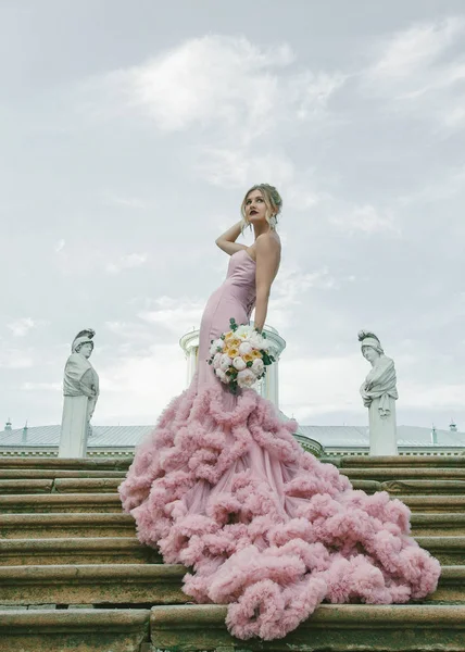 Mode de mariée. Portrait de jeune mariée moderne avec maquillage élégant et coiffure tenant bouquet de pivoine dans ses mains . — Photo